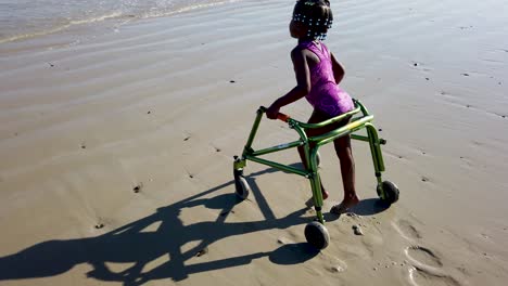 Kleines-Mädchen-Mit-Zerebralparese,-Das-Am-Strand-Spielt