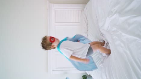 Superhero-boy-jumping-on-the-bed