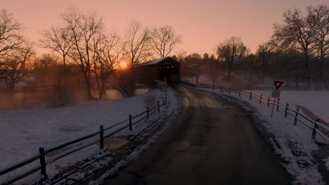 An-Amish-horse-drawn-buggy-enters-the-Hunsecker's-Mill-Covered-Bridge-at-sunset-Lancaster,-Pennsylvania