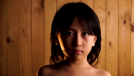 Dramatische-Beleuchtung-Junger-Asiatischer-Junge-Mit-Nacktem-Oberkörper,-Der-Auf-Holzhintergrund-In-Die-Kamera-Schaut