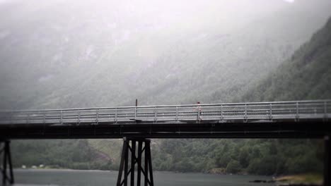 Man-walking-on-bridge-in-slow-motion,-with-beautiful-background-view