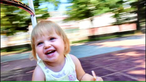 Entzückendes-Kleinkindmädchen,-Das-Lächelt-Und-Lacht-Und-Die-Fahrt-Auf-Dem-Kreisverkehr-Genießt