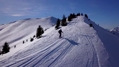 Drone-Siguiendo-Skiier-Desollado-En-La-Cresta-De-La-Montaña