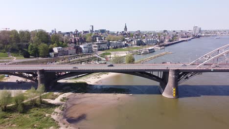 Nijmegen-Bridge-and-City-Skyline-in-Gelderland,-Netherlands---Aerial-Pan-Rigt