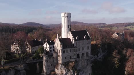 Neugotische-Burg-Lichtenstein-Auf-Felswand-Mit-Morgensonne,-Antenne