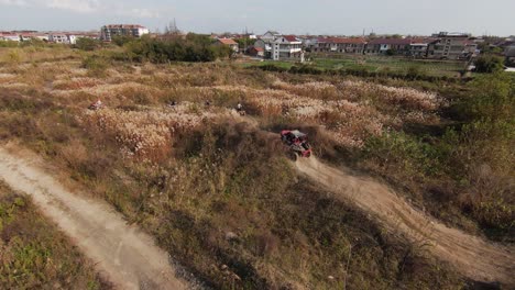 Aerial-following-view-on-4x4-utv-offroad-car-driving-over-the-dusty-terrain