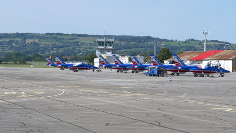 Alpha-Jets-of-Patrouille-de-France-taxiing-on-Airport-Apron,-Sunny-Day
