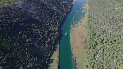 Ferry-boat-traveling-upstream-towards-Krka-National-Park,-aerial