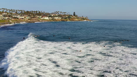Aerial-pan-left-of-surfers-in-La-Jolla-on-sunny-day