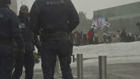 Police-officers-guard-a-protest-on-a-winter-day-in-Helsinki,-Finland