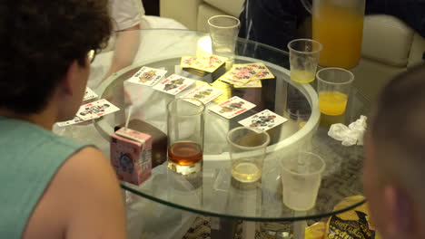 Young-people-playing-board-games-and-poker-in-Honkong,-on-a-glass-table