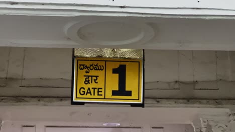 Hanging-from-the-ceiling-is-a-trilingual-yellow-sign-board-with-the-number-1-and-the-word-gate