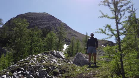 Hiker-watching-admiring-walking-uphill-followed,-Rockies,-Kananaskis,-Alberta-Canada