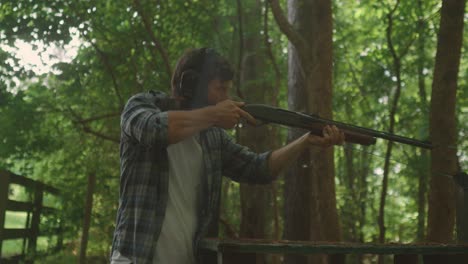 gunshot-shooting-training-session-in-the-forest,-slow-motion-of-caucasian-male-with-earmuffs