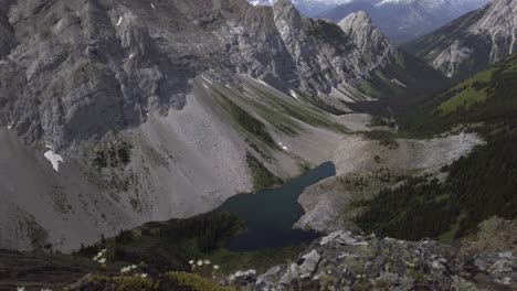 Mountain-lake-revealed-behind-rock-tilt-Rockies-Kananaskis-Alberta-Canada