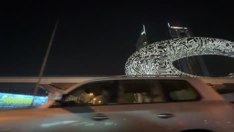 Night-time-drive-by,-the-Museum-of-the-Future,-Dubai,Sheikh-Zayed-Road