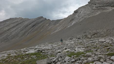 Hiker-walking-trough-mountain-amphitheater-followed-Rockies-Kananaskis-Alberta-Canada
