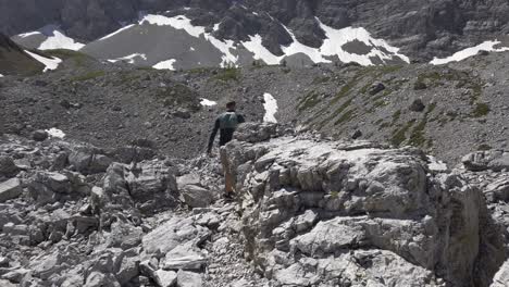 Hiker-walking-among-rocks-valley-followed-Rockies,-Kananaskis,-Alberta-Canada