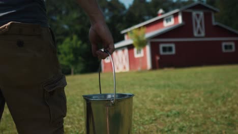 farmer-carrying-bucket-filled-with-fresh-natural-milk,-walking-in-rural-farm-morning-routine-lifestyle-off-grid