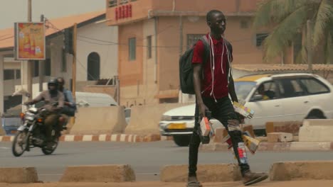 Afrikanischer-Männlicher-Elektronik-straßenhändler,-Der-In-Slowmotion-Vorbeigeht---Togo,-Afrika