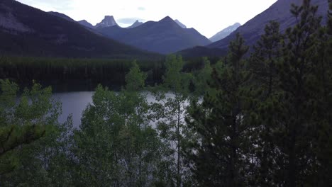 Paddle-boards-on-pond-in-park-mountains-and-forest-revealed-Rockies-Kananaskis-Alberta-Canada