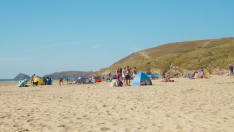 English-People-Spending-Summer-On-Sandy-Shore-At-Perranporth-Beach-In-Cornwall,-United-Kingdom---Wide-Shot