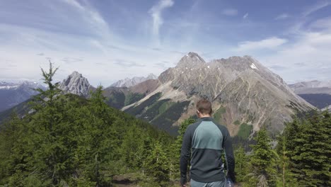 Hiker-descending-through-pine-trees-on-mountain-range-Rockies-Kananaskis-Alberta-Canada
