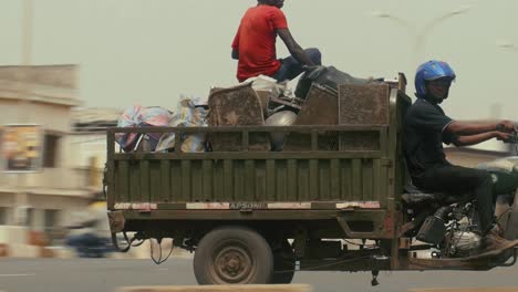 African-local-waste-collection-motor-Tricycle-driving-by-in-a-street---Lomé,-Togo,-Africa