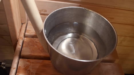 Close-up-view-of-water-being-taken-out-from-a-steel-container-containing-water-for-the-purpose-of-cooking-in-the-kitchen