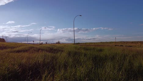 Highway-approached-at-low-angle-grass-POV-Alberta-Canada
