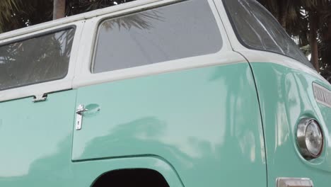 A-close-up-shot-of-the-hub-cap-of-a-classic-VW-Bus-tilting-up-to-reveal-the-passenger-door,-Pattaya,-Thailand