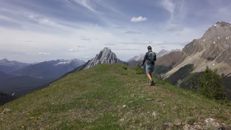 Excursionista-Caminando-En-La-Cima-De-Un-Avión-De-Montaña-Tomando-Fotografías-De-Las-Montañas-Rocosas,-Kananaskis,-Alberta,-Canadá