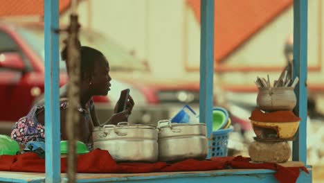 Afrikanische-Lebensmittelverkäuferin,-Die-Mit-Ihrem-Smartphone-Eine-Sprachnachricht-Macht
