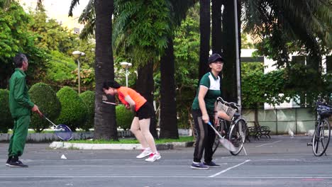 Morning-exercise-in-public-park-in-Saigon,-Vietnam,-people-play-badminton