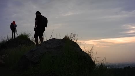 Silhouette-Eines-Mannes,-Der-Den-Hügel-Hinaufgeht,-Um-Die-Natürliche-Landschaft-Bei-Sonnenaufgang-Zu-Genießen
