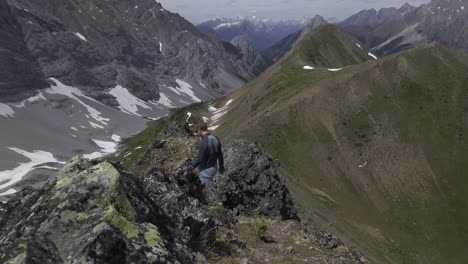 Hiker-on-mountain-ridge-revealed-walking,-Rockies-Kananaskis-Alberta-Canada