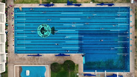 Aerial-View-Directly-Above-People-Swimming-in-Lanes-in-Outdoor-Pool