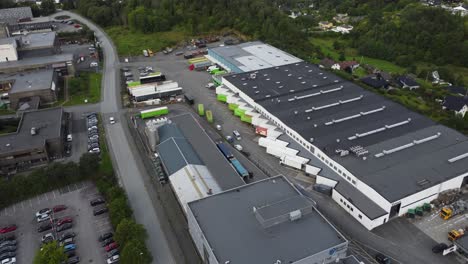 Bring-express-terminal-building-and-warehouse-in-Nesttun-outside-Bergen-Norway---Aerial-showing-building-exterior-and-many-trucks-parked-inside-hub