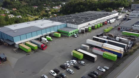 Posten-Bring-terminal-in-Nesttun-outside-Bergen-Norway---Aerial-showing-terminal-building-with-many-delivery-trucks-parked-inside-hub-for-loading-and-discharging-goods