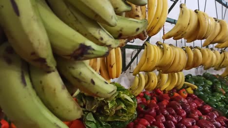 Kochbananen-Und-Bananen,-Die-In-Einem-Obstladen-Hängen