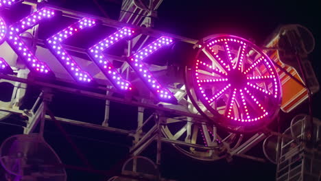 Neon-lights-flash-as-people-enjoy-summer-evening-thrills-on-The-Zipper-ride
