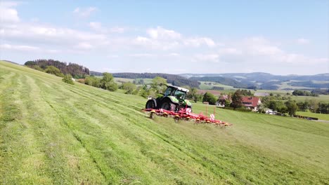 Aerial-Tractor,-agricultural-machine-making-hay,-driving-over-field