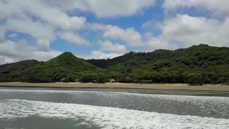 drone-aerial-video-in-nicaragua-beach,-san-juan-del-sur,-palm-,-managua,-rivas,-bicyclist-on-the-beach
