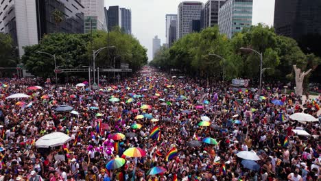 Vista-Aérea-De-Una-Plaza-Llena-De-Gente-Diversa,-Durante-El-Desfile-Del-Orgullo-Gay,-En-La-Ciudad-De-México---Seguimiento,-Disparo-De-Drones