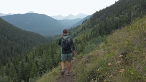 Hiker-walking-downhill-on-a-trail-in-high-altitude-Rockies-Kananaskis-Alberta-Canada