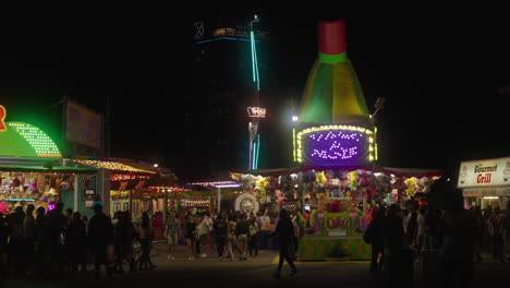 Neonlichter-Leuchten,-Wenn-Menschen-In-Einer-Geschäftigen-Nacht-Im-CNE-Karnevalsspiele-Spielen