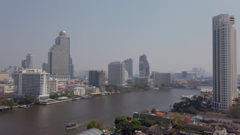 Zeitlupenansicht-Des-Flusses-Chao-Phraya-In-Bangkok-Mit-Bangkok-Higrise-Gebäude-Am-Ufer-Des-Flusses