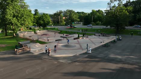 Group-of-people,-young-adults-gather-to-skate-and-enjoy-outdoor-park