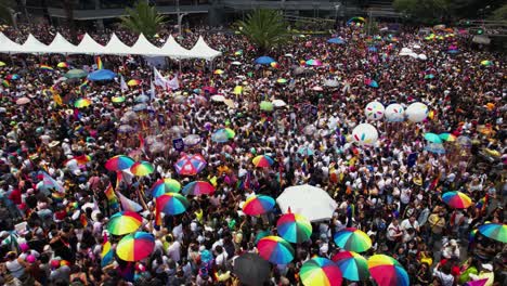Rainbow-umberellas-and-inflatable-gear-at-Gay-pride-celebrations---aerial-view