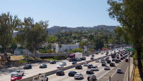 The-northbound-101-freeway-carries-early-afternoon-traffic-headed-to-the-Valley-through-Cahuenga-Pass-in-Los-Angeles,-California-on-a-summer-day